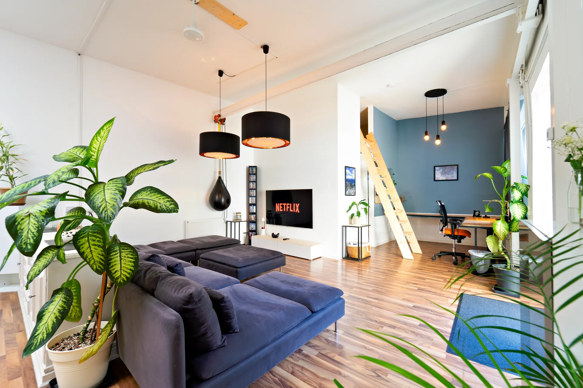Heller Wohnbereich im Industrial-Loft mit Sofa und Smart-TV