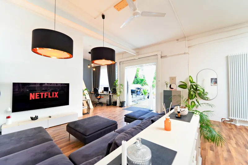 Heller Wohnbereich im Industrial-Loft mit Sofa und Smart-TV