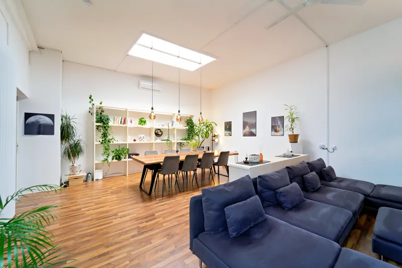 Heller Wohnbereich im Industrial-Loft mit Sofa und Smart-TV