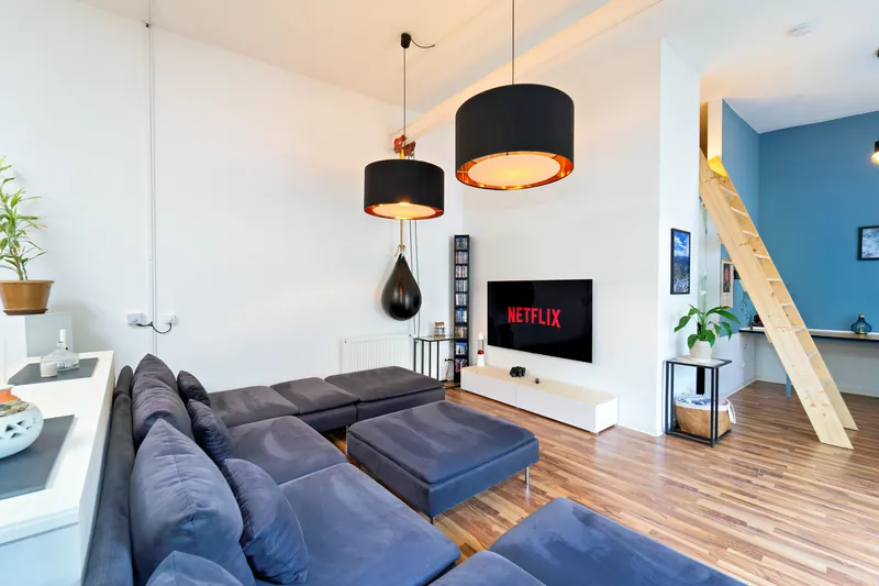 Heller Wohnbereich im Industrial-Loft mit Sofa und Smart-TV