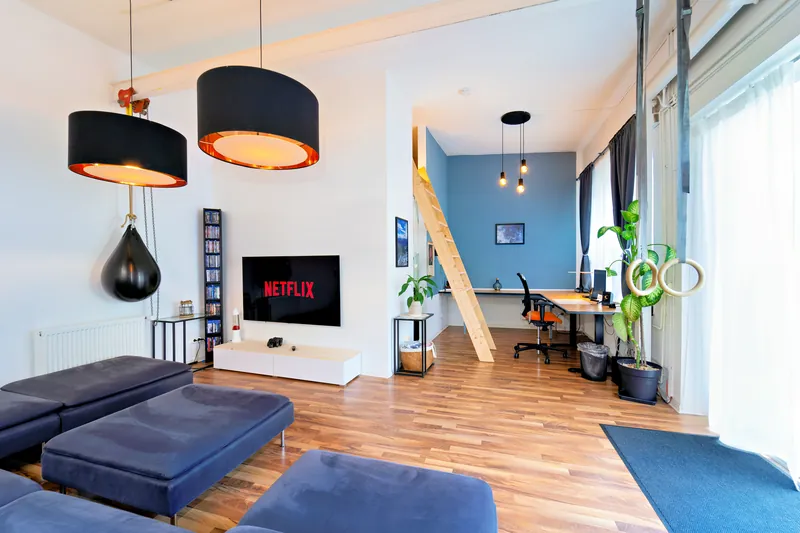 Heller Wohnbereich im Industrial-Loft mit Sofa und Smart-TV