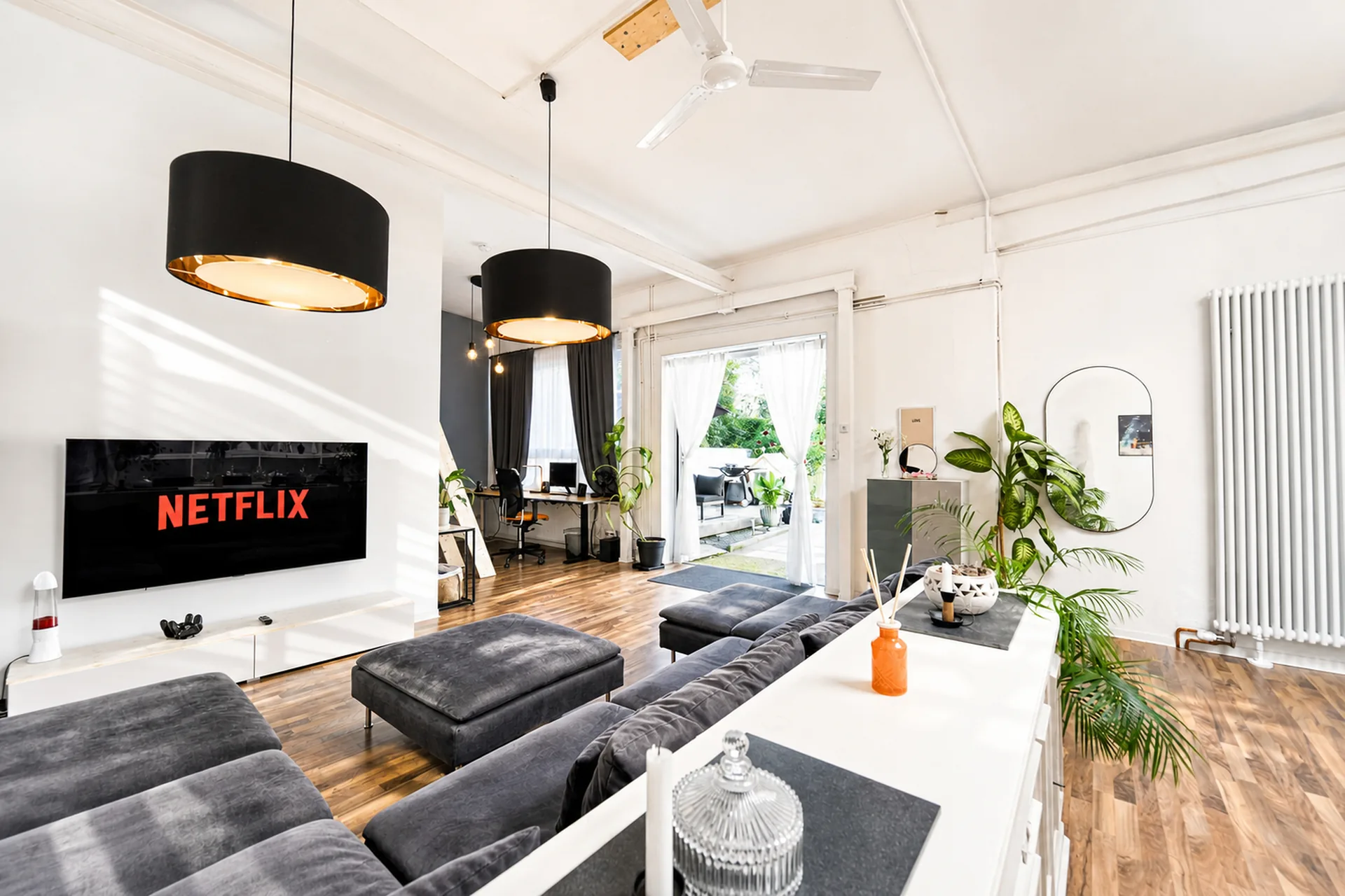 Bright living area in the industrial loft with sofa and smart TV