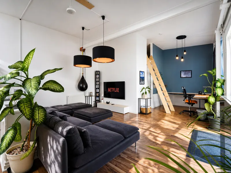 Bright living area in the industrial loft with sofa and smart TV